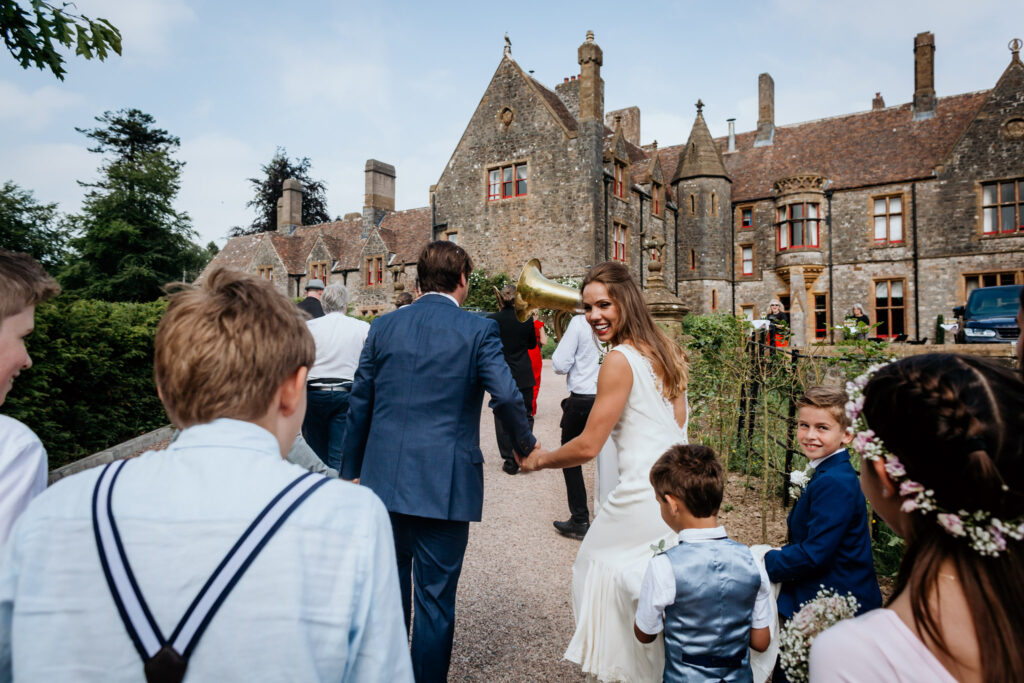 couple lead their guests back to the main house at huntsham court
