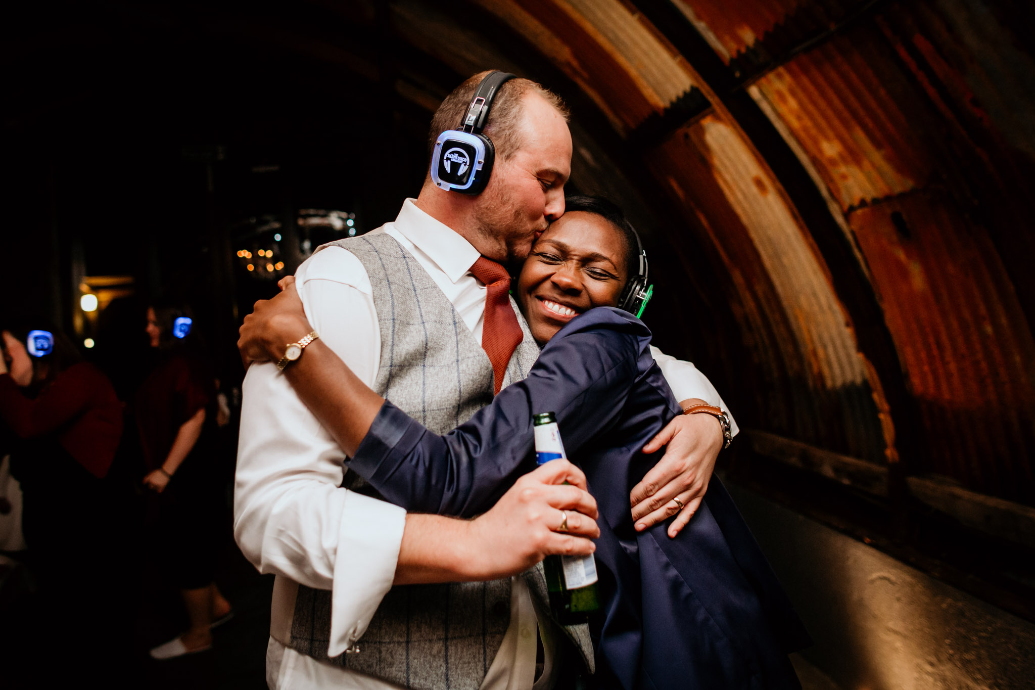 groomsman and guest embrace in the nissen hut anran wedding devon