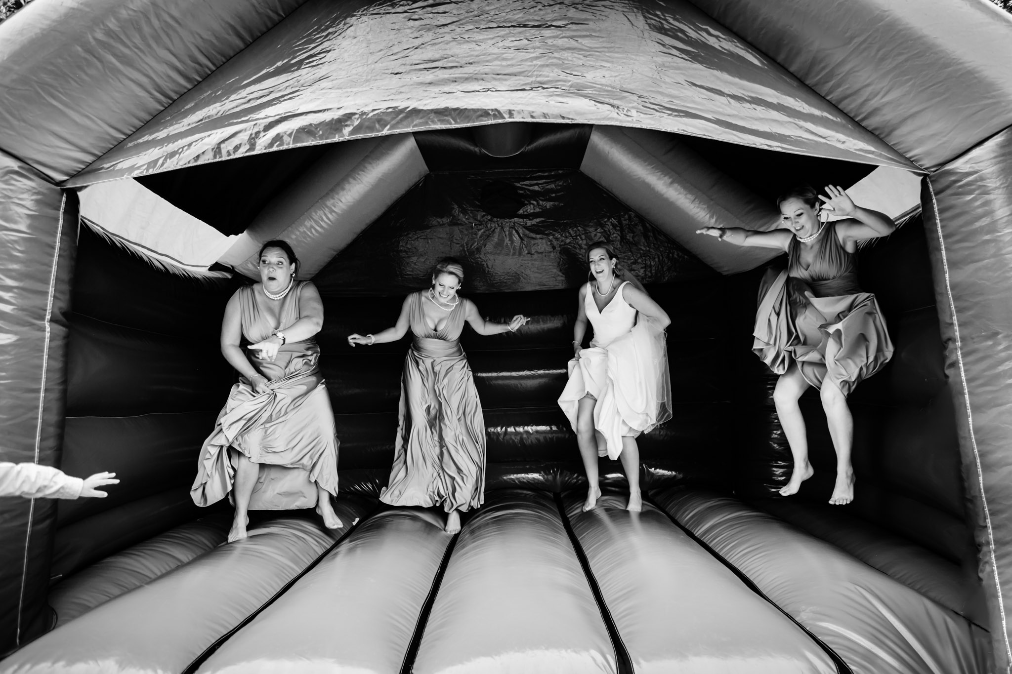 bride and bridesmaids on the bouncy castle at lavender house wedding ashburton devon