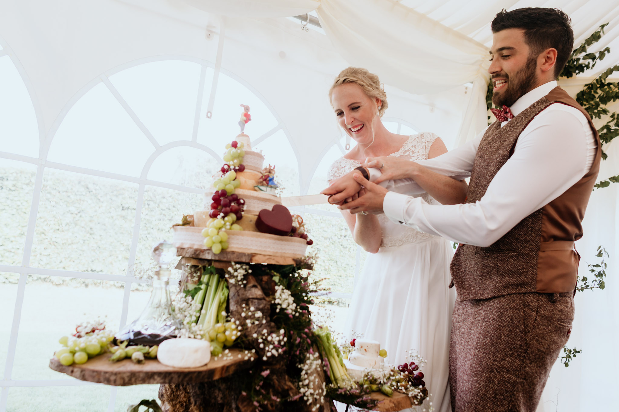 couple cutting the cheese cake at bridestowe farm wedding devon