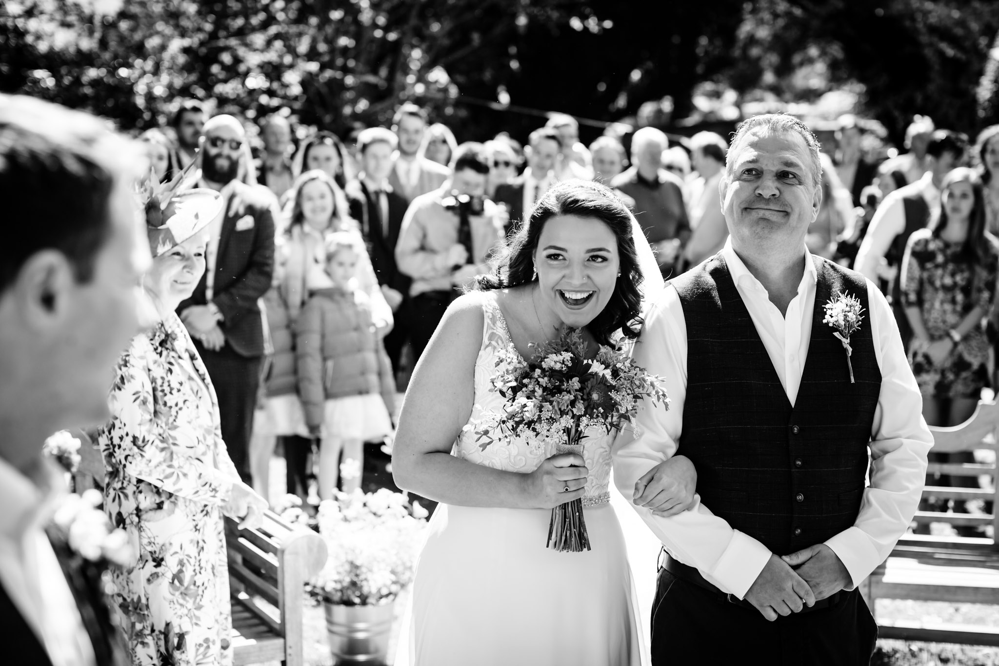 a bride with her emotional dad walking down the aisle at a summer colehayes park wedding