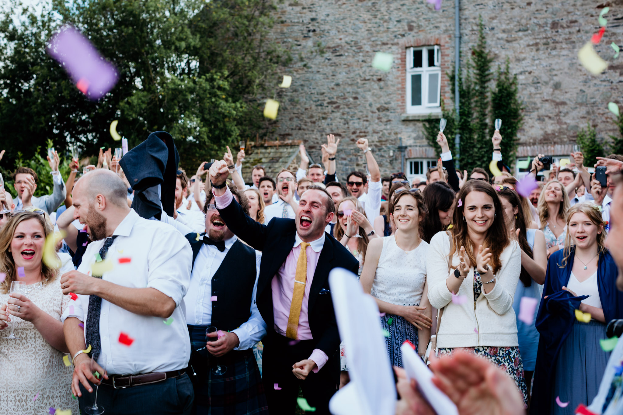 confetti canons go off and guests all celebrate at anran summer wedding devon