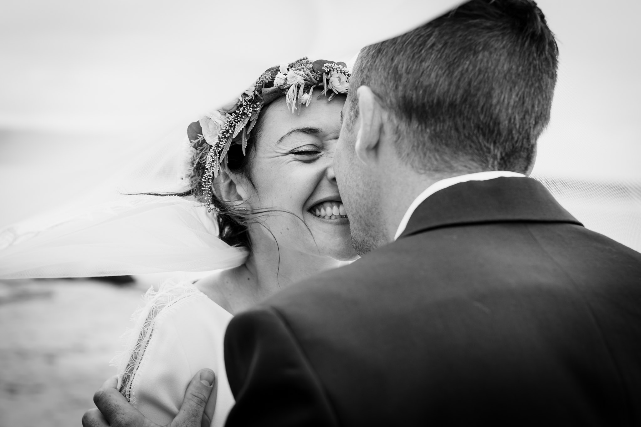 a bride and groom embrace at a daymer bay beach wedding cornwall