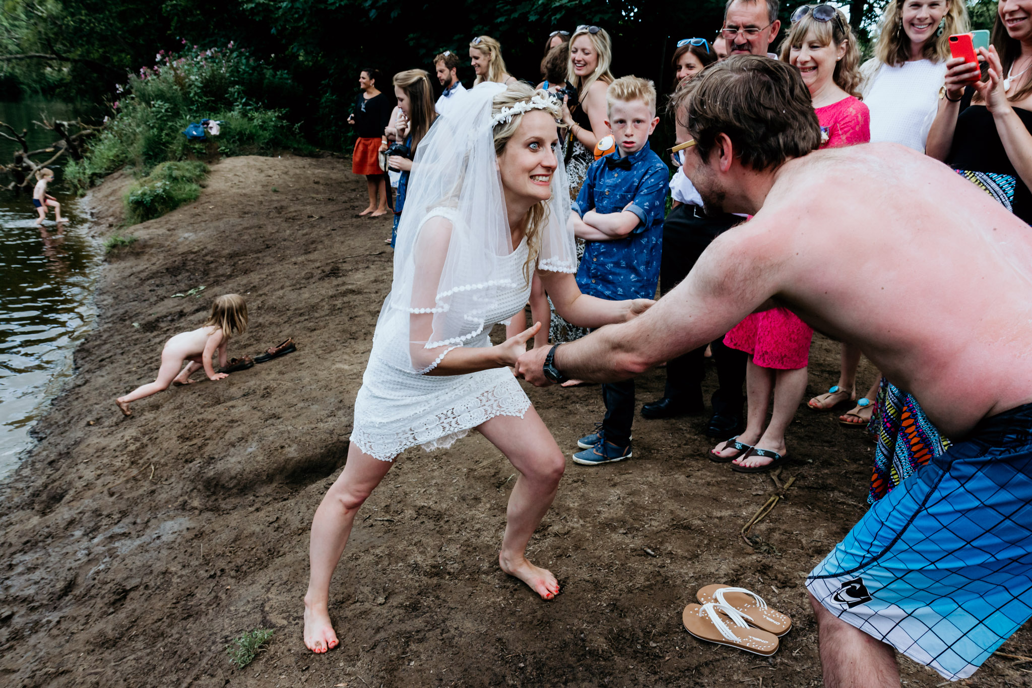bride pulls her new husband into the river dart at dartington wedding devon