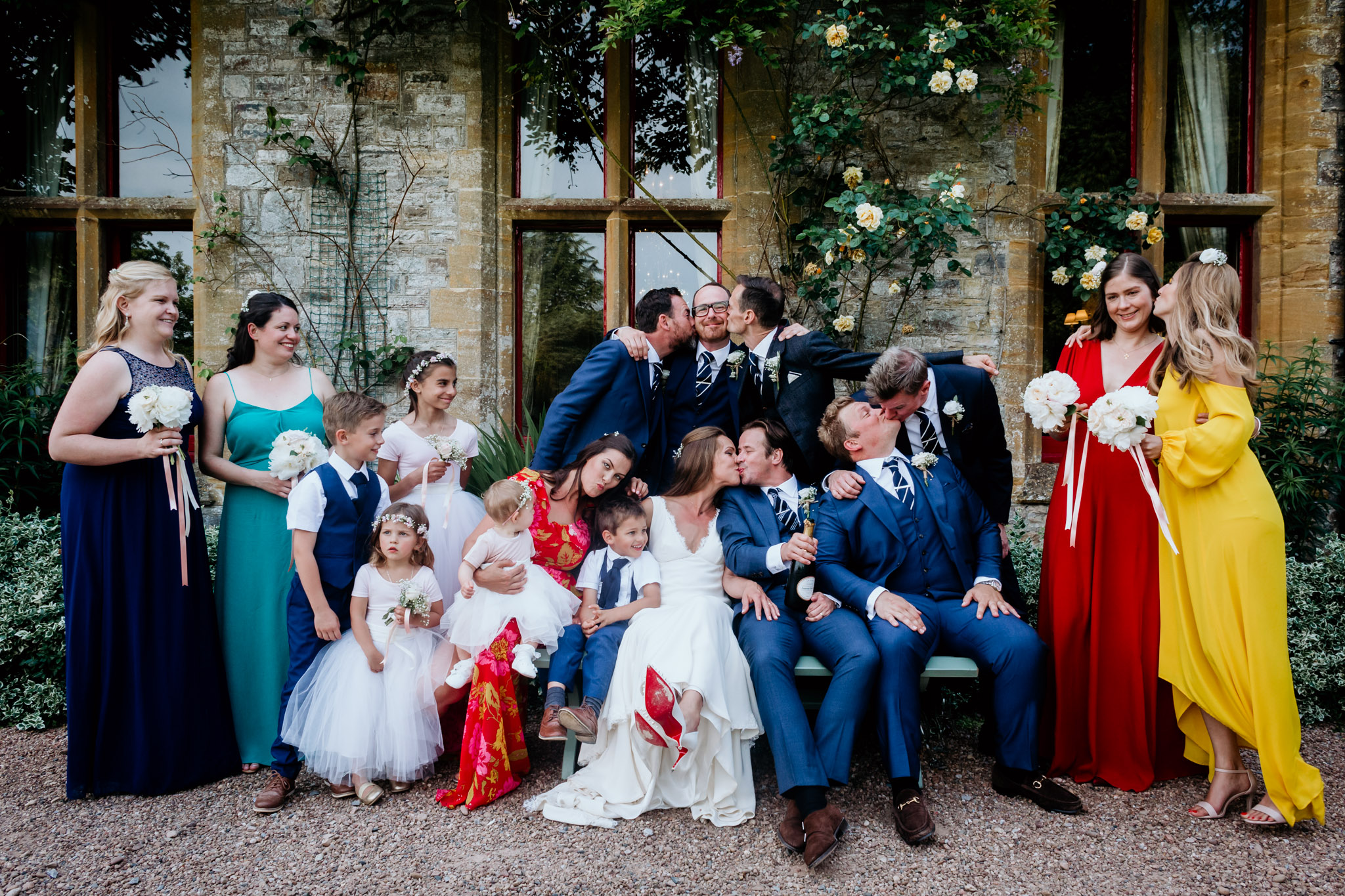 fun group photo at a wedding at huntsham court devon with everyone kissing