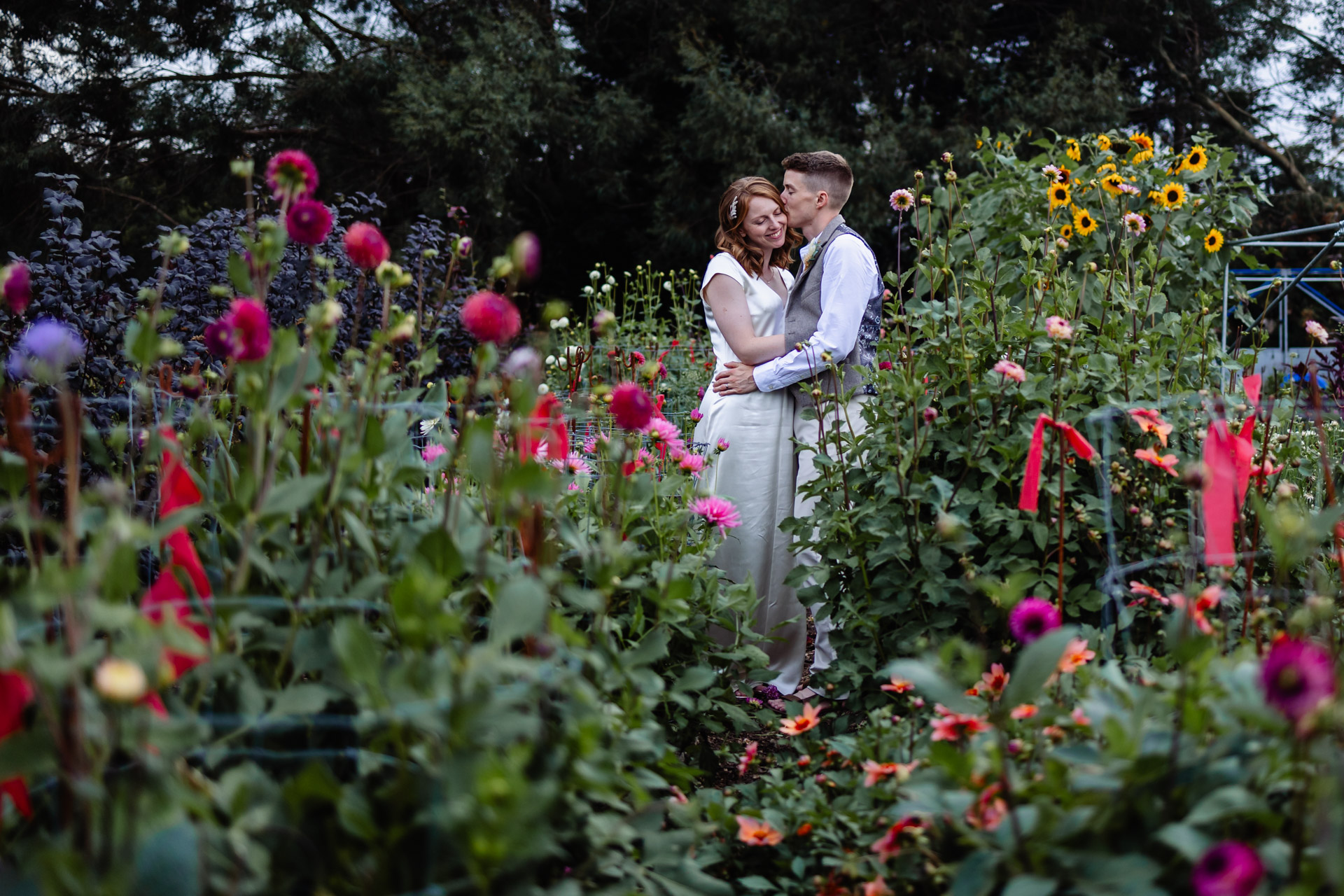 couple having a moment among the flower beds at warborne farm, new forest