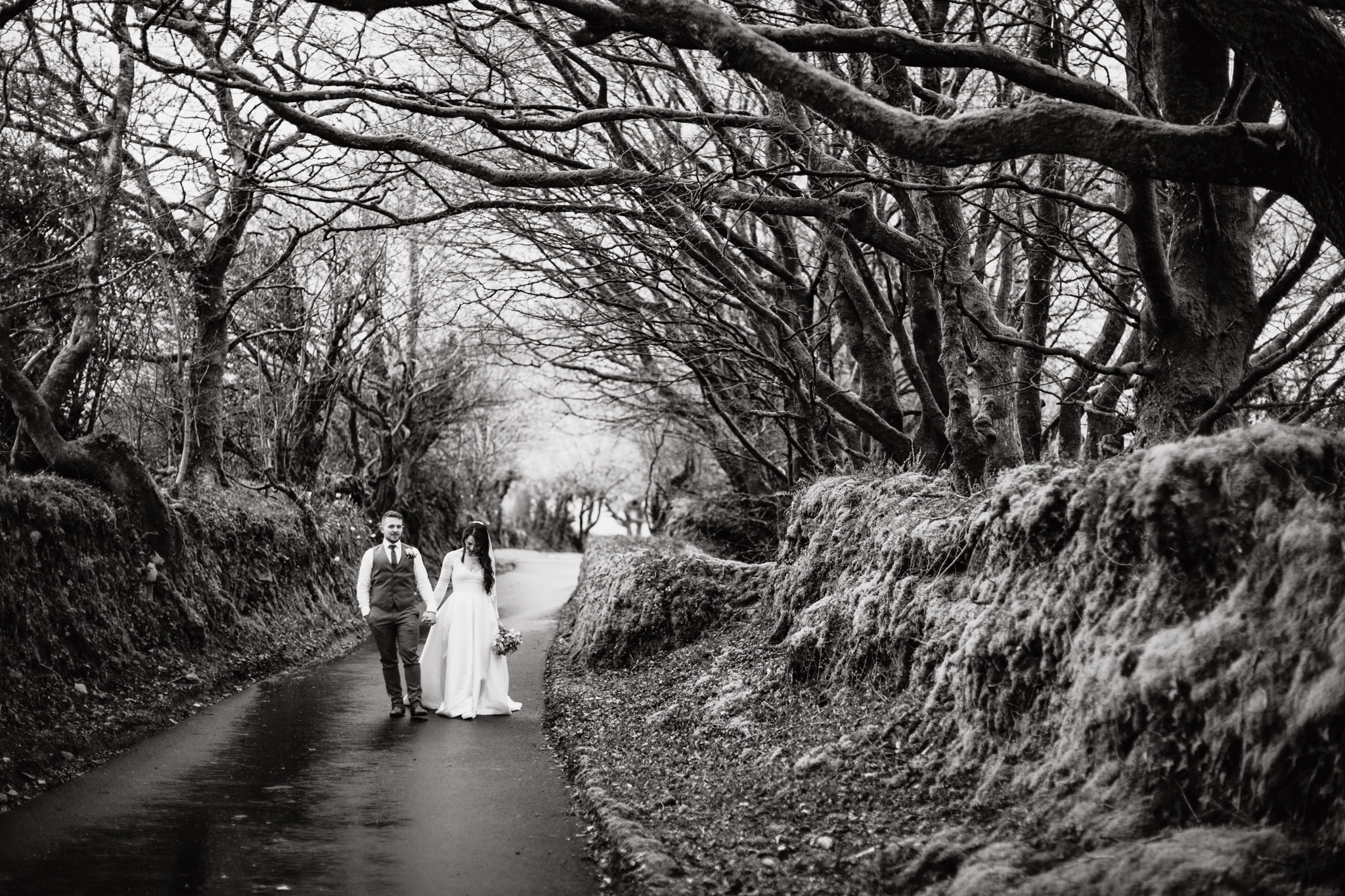 bride and groom in winder treelined driveway at trevenna barns cornwall wedding