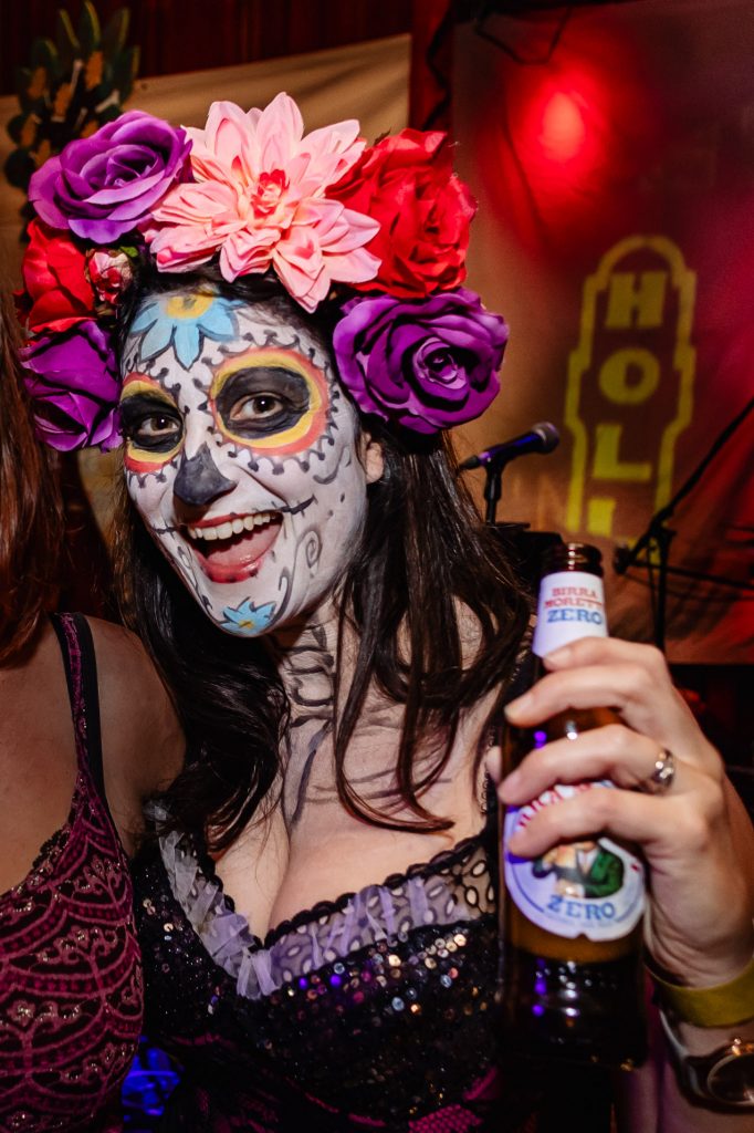 cara from meet me on the hill in day of the dead facepaint holding a beer enjoying herself on a night out