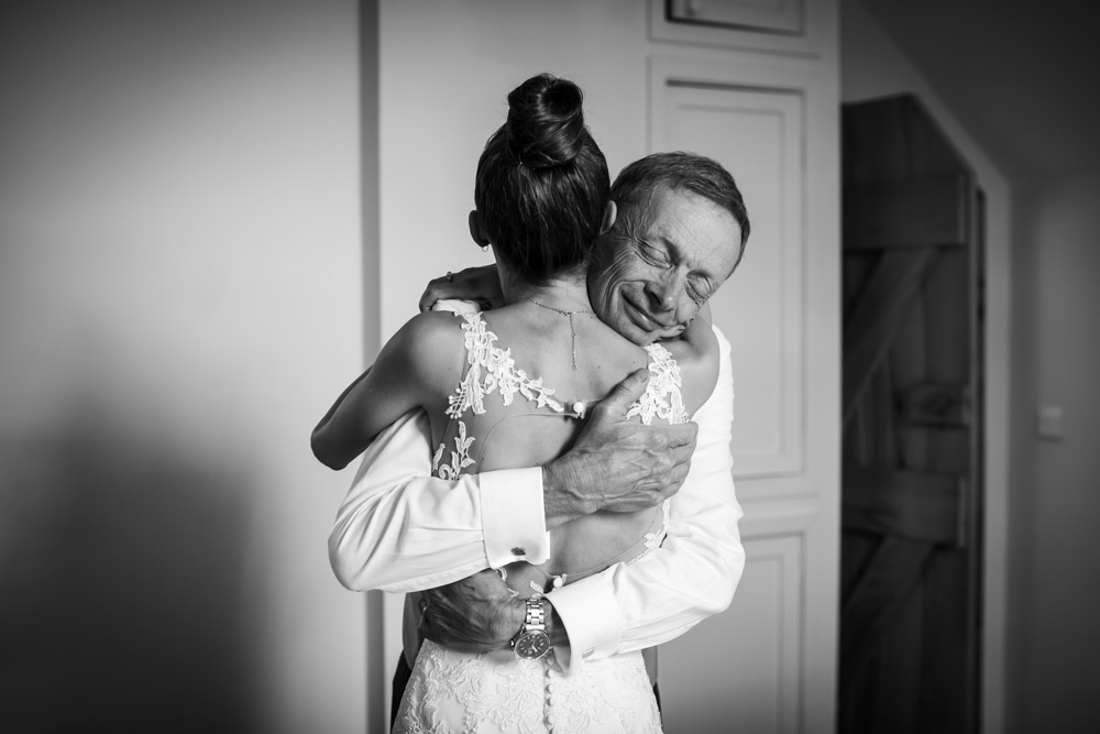 a father hugs his daughter before the wedding