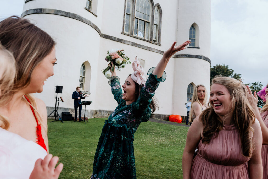 girl catches the bouquet outside at haldon belvedere wedding