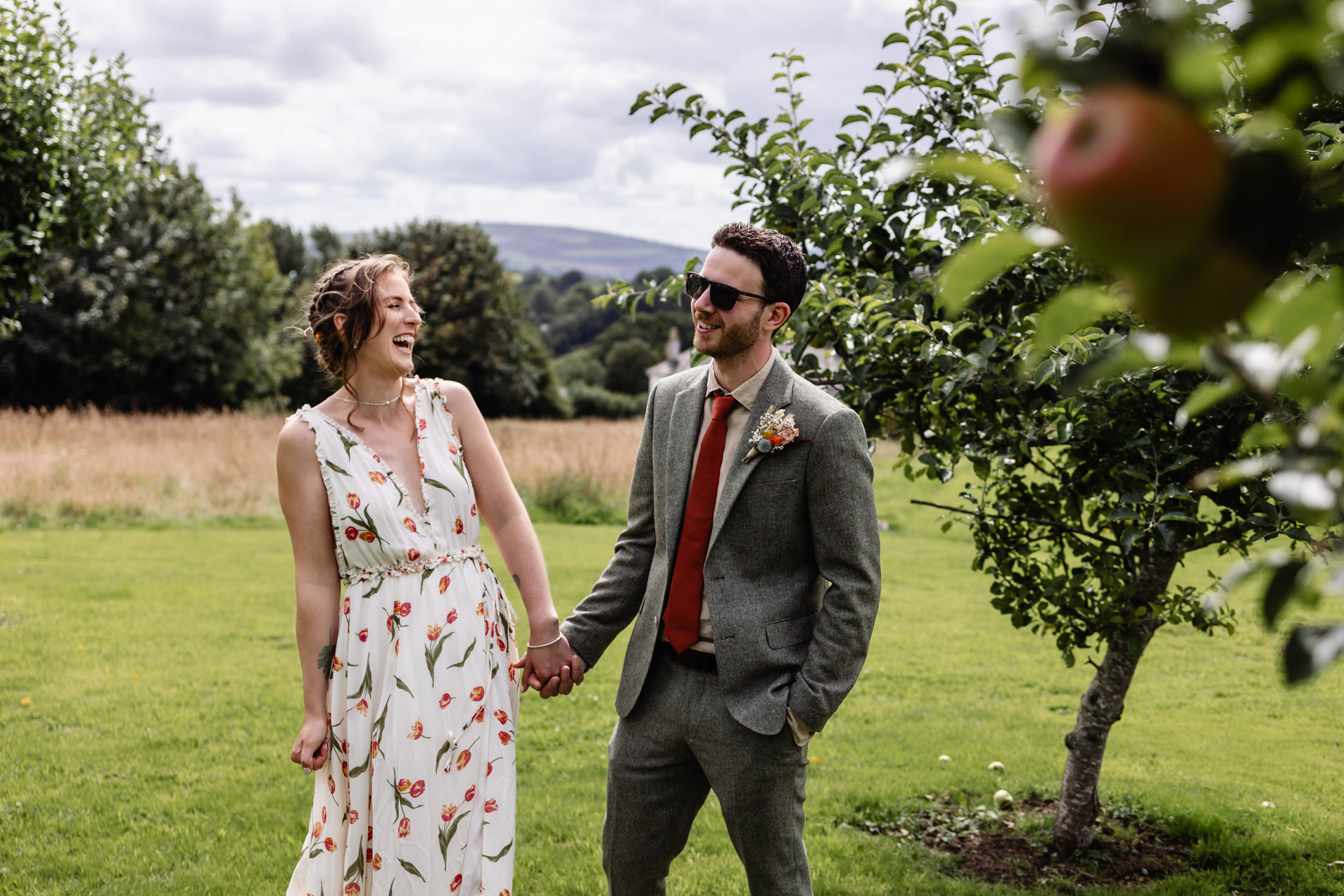 a couple laugh in the orchard at wonwood barton wedding devon