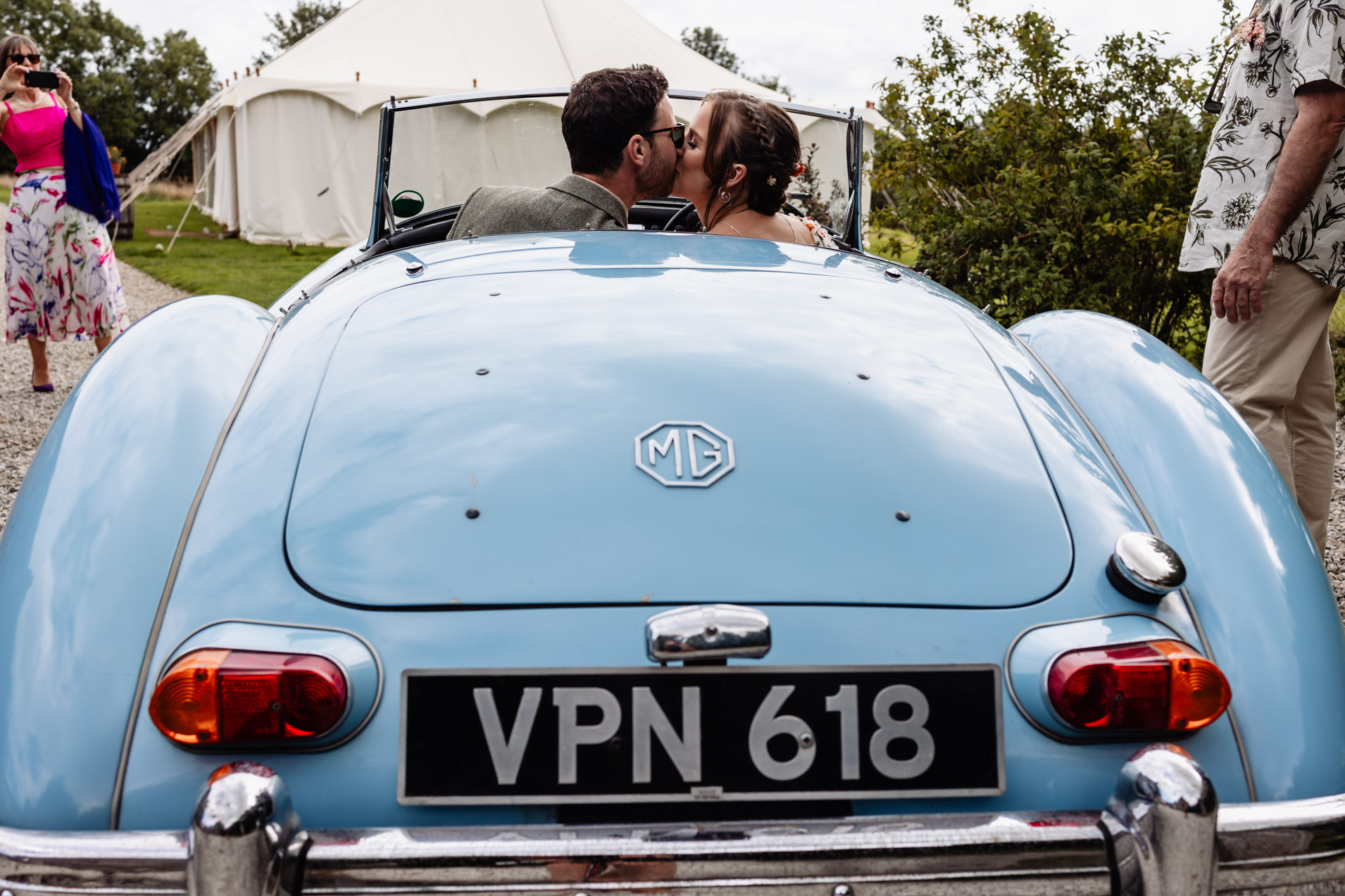 bride and groom kiss in vintage MG car at wonwood barton wedding