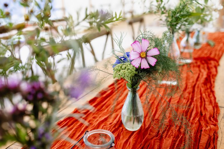 vases of wildflowers as table decorations in the marquee at wonwood barton wedding