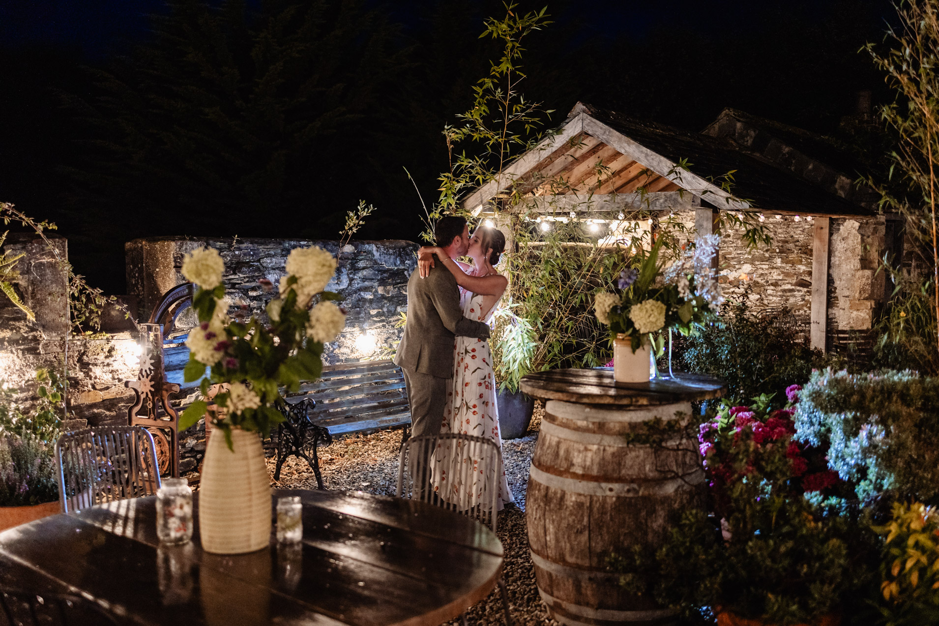 bride and groom embrace in the lit up courtyard at night at wonwood barton