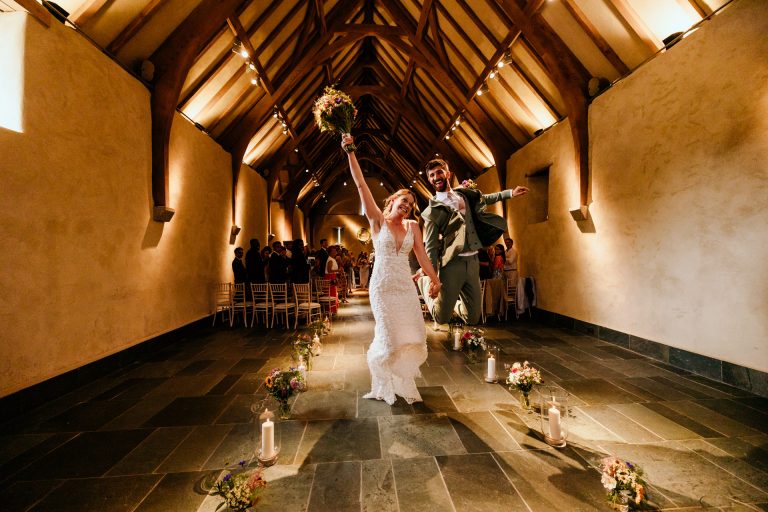 celebrating down the aisle with a jump at the great barn devon