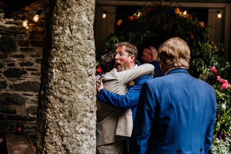 guest hugs groom and makes funny facial expression