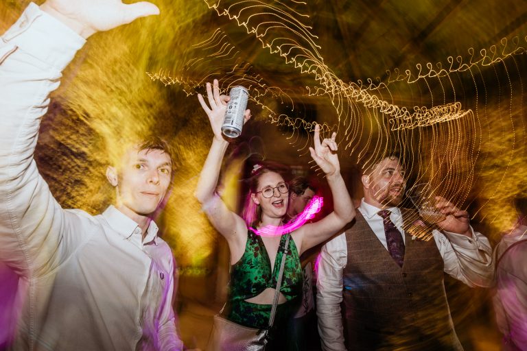 guest dances with arms up in long exposure shot