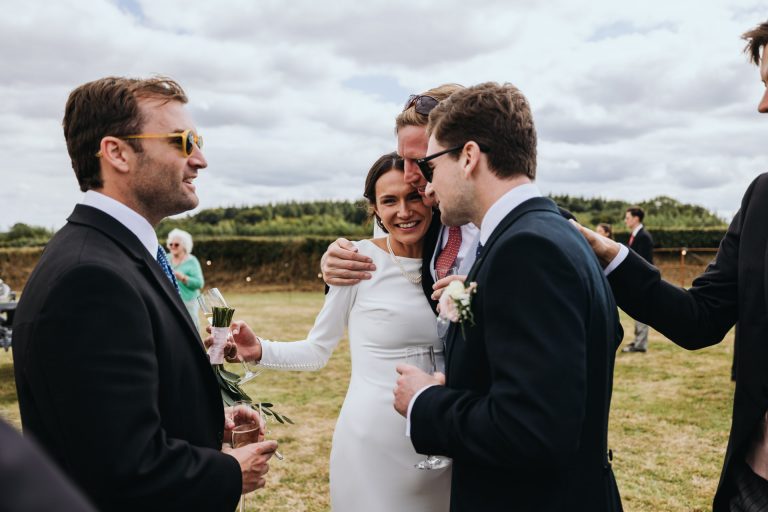 groomsmen hug the bride to congratulate her