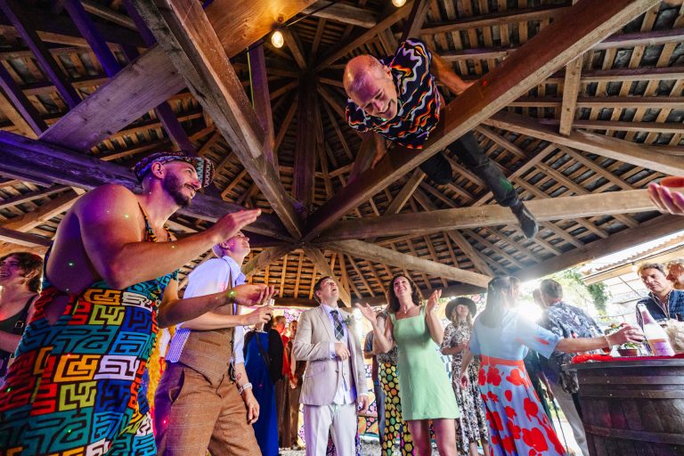 onlookers clap as a guest climbs over the rafters