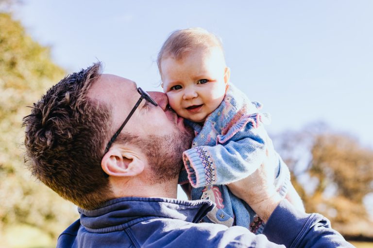 a 3 month old baby being kissed by her dad