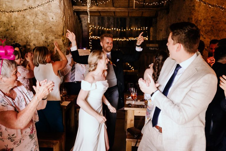 Bride and groom dance in to make an entrance to the lovely rustic barn at higher eggbeer