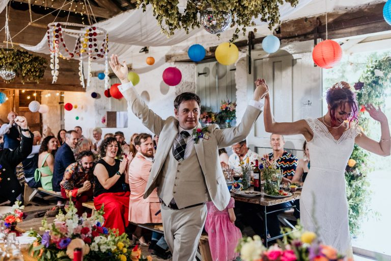 bride and groom make an entrance in the barn at bradstone manor