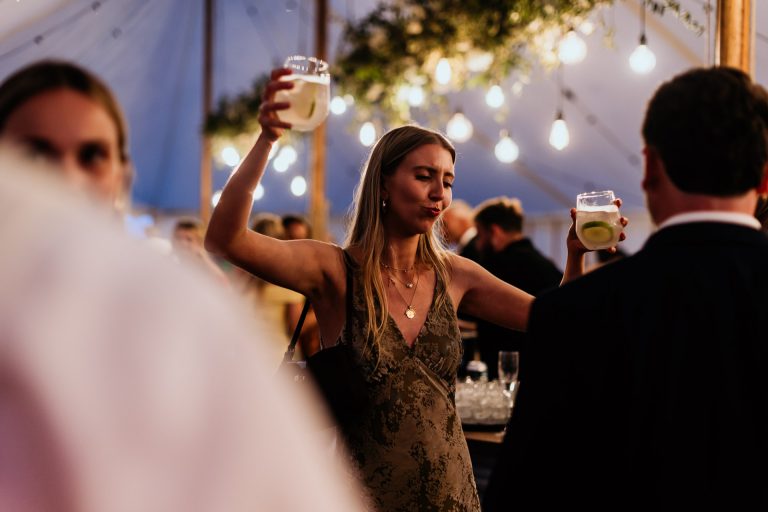 evening dancing - guest dances with 2 drinks in hand