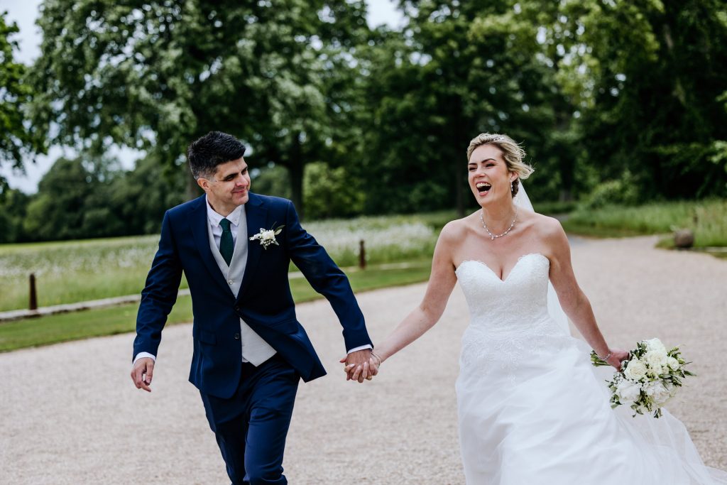 bride and groom run and laugh at rockbeare manor