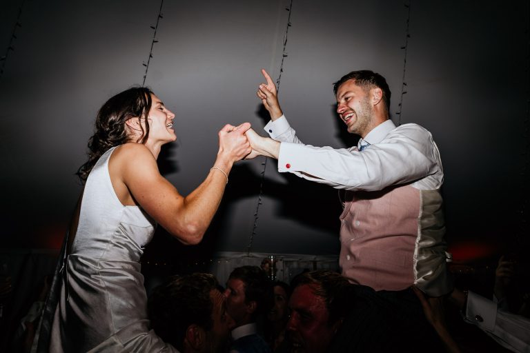 bride and groom dance up on shoulders devond marquee wedding
