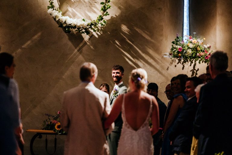 groom emotionally watches his bride come down the aisle in the great barn devon