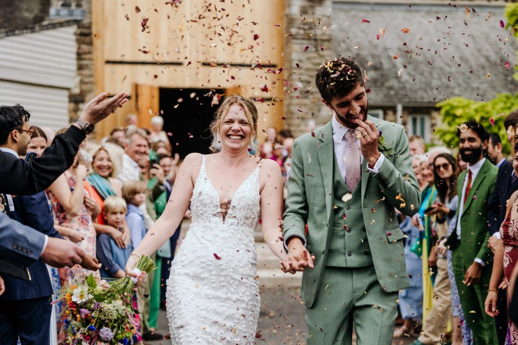 groom picks confetti out of his teeth at the great barn devon