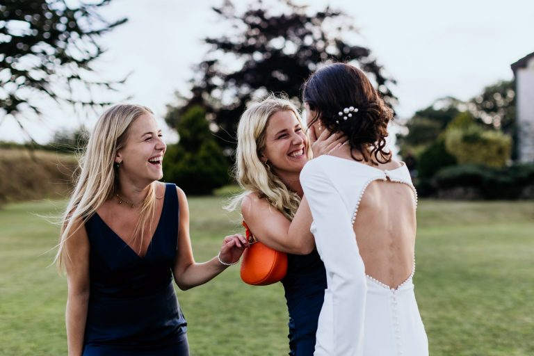 bridesmaids congratulate the bride at a devon farm marquee wedding