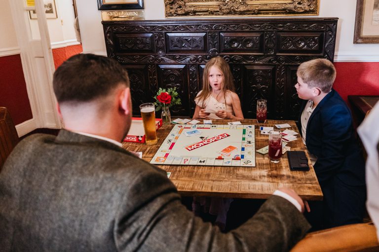 a young guest plays monopoly at a wedding
