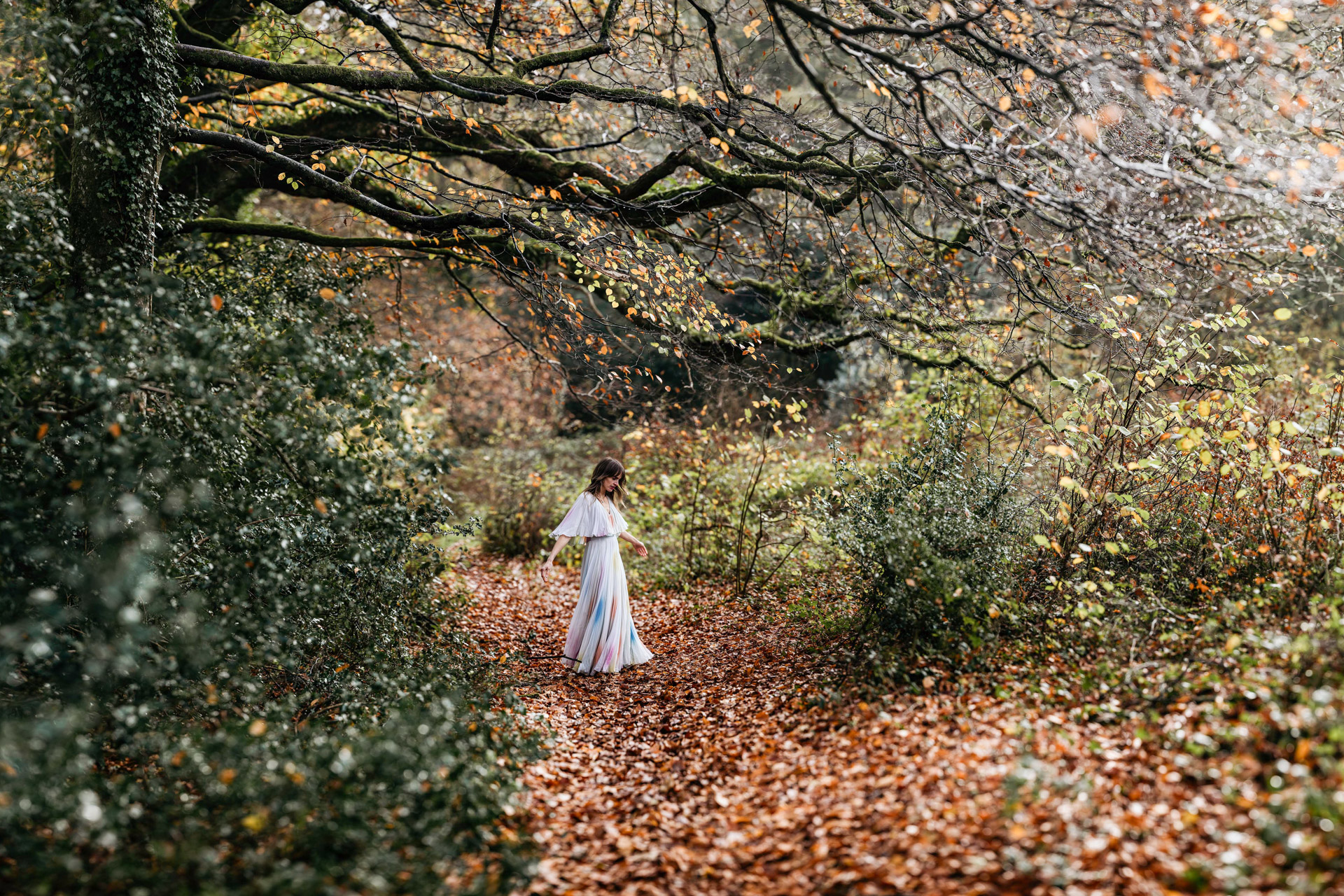 india bourne the musician in a vintage seventies dress spinning in the woods