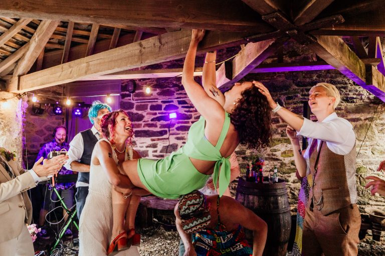 bride lifts a friend up to the rafters
